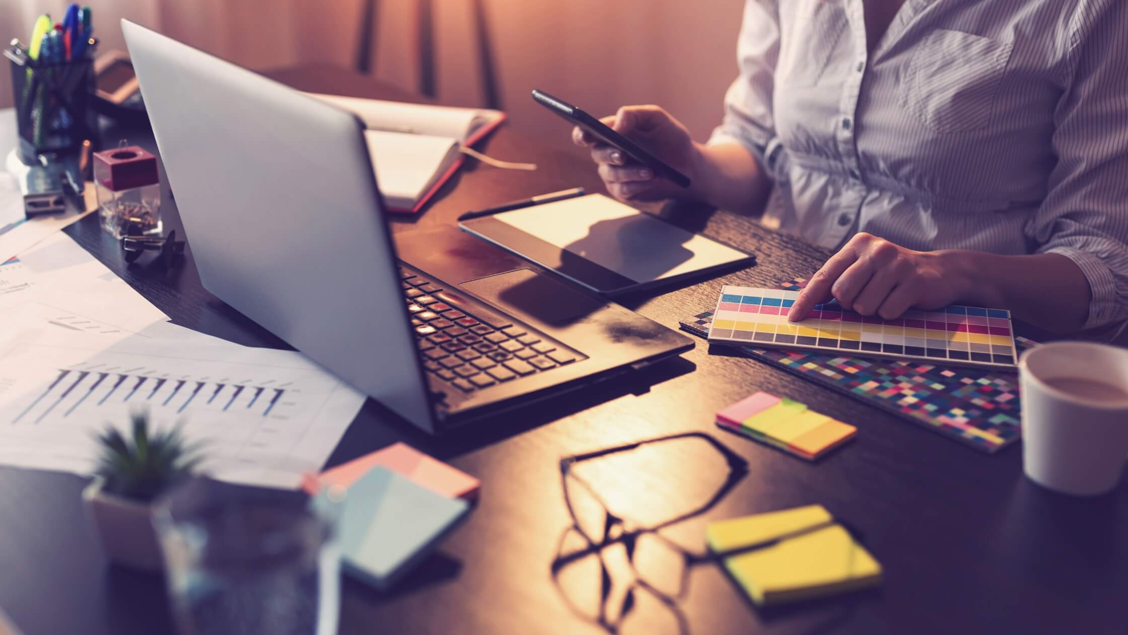 Mujer emprendedora eligiendo su paleta de colores y trabajando con su laptop