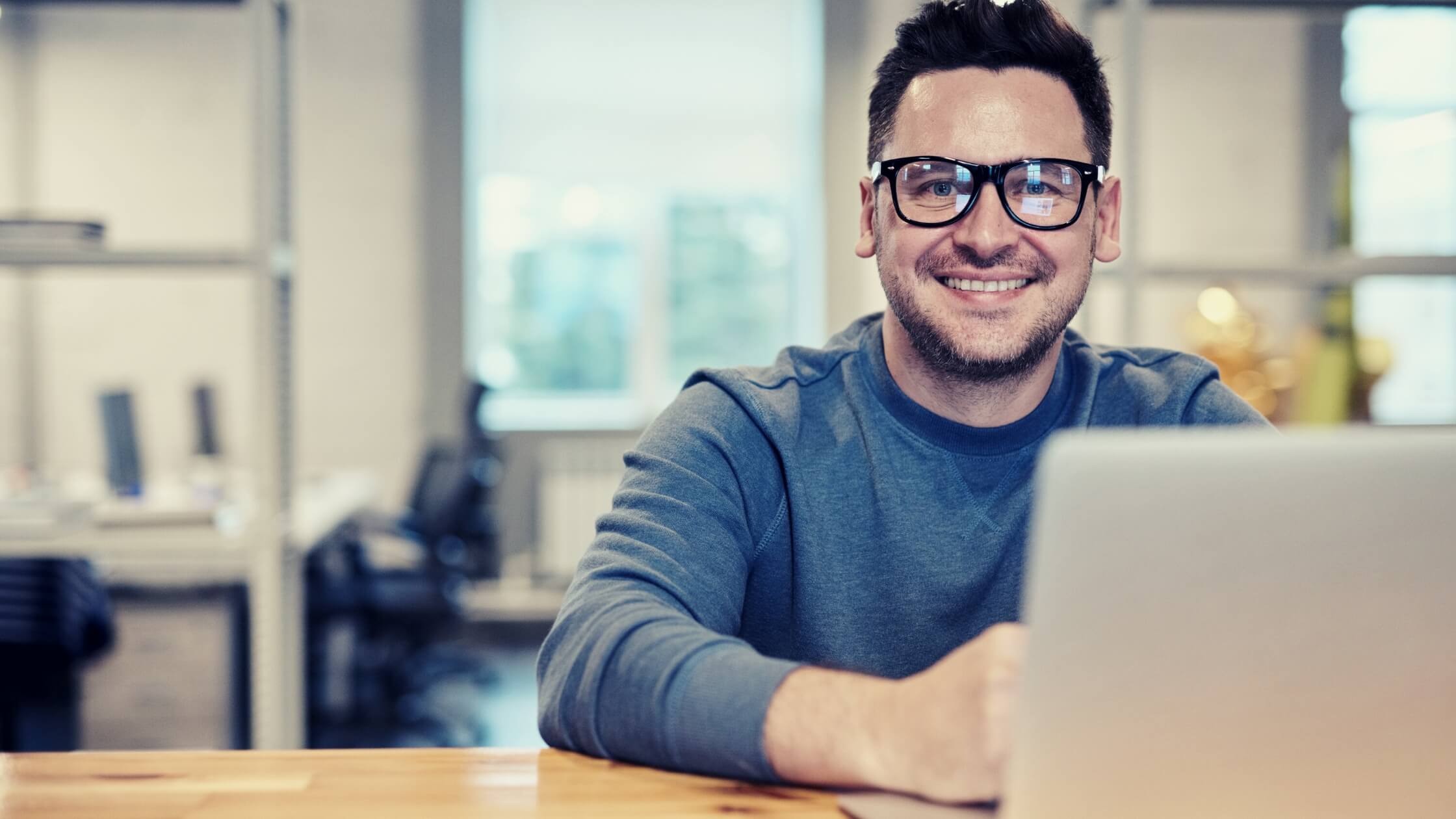 Hombre emprendedor con laptop y sonriendo