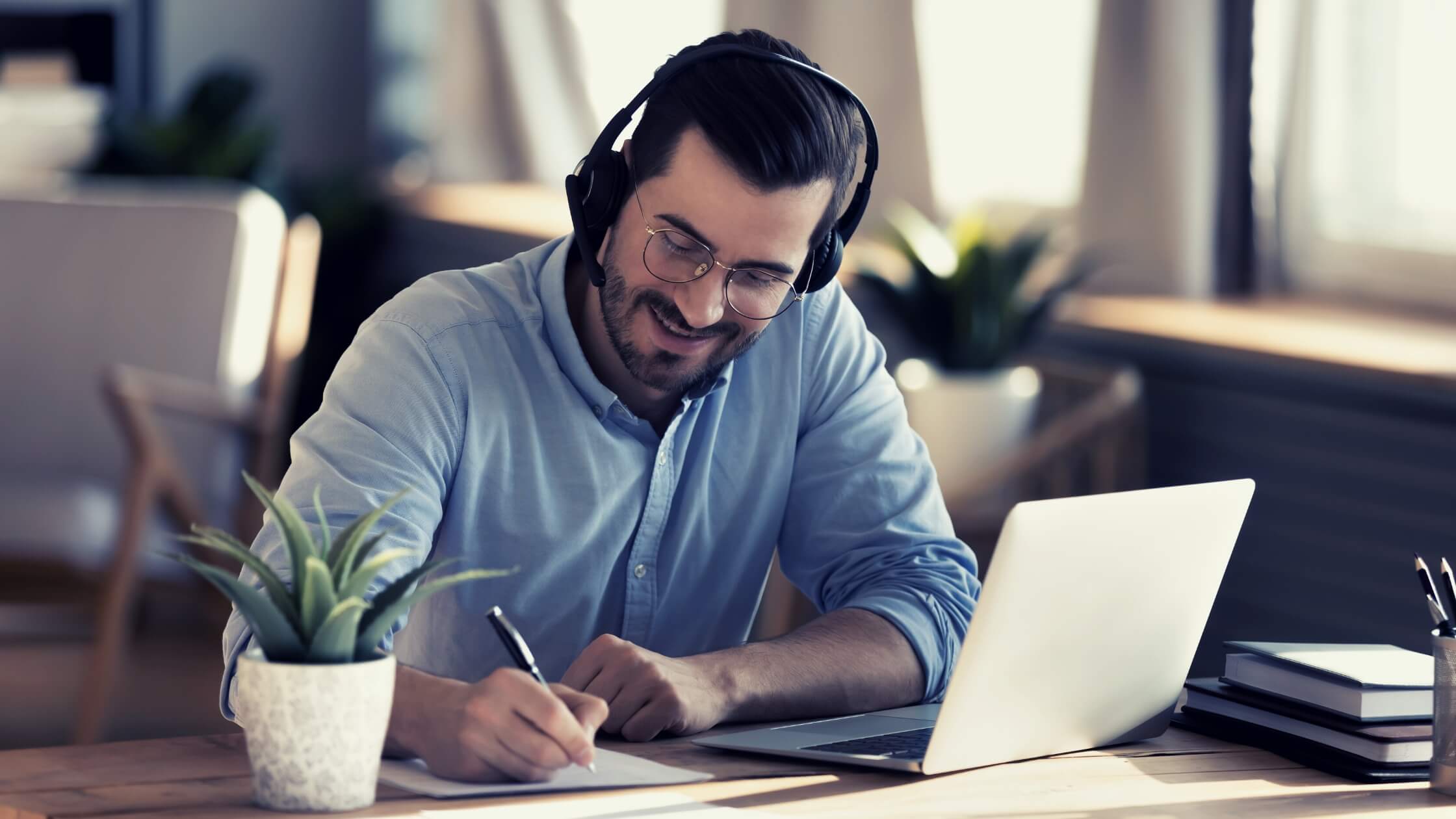 Hombre emprendedor, ejecutivo, con audifonos trabajando con su laptop