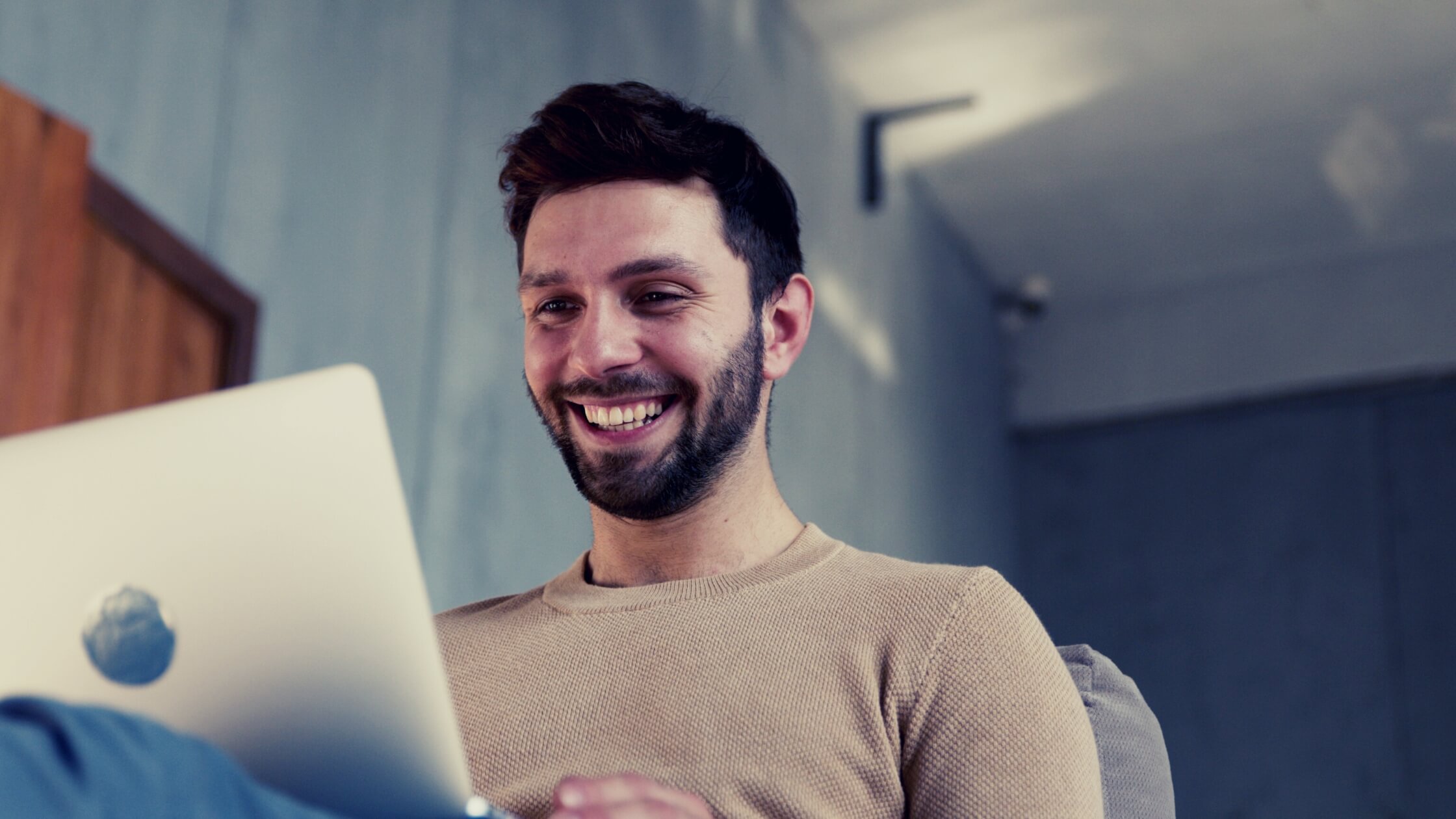 Hombre emprededor sonriendo trabajando con su laptop