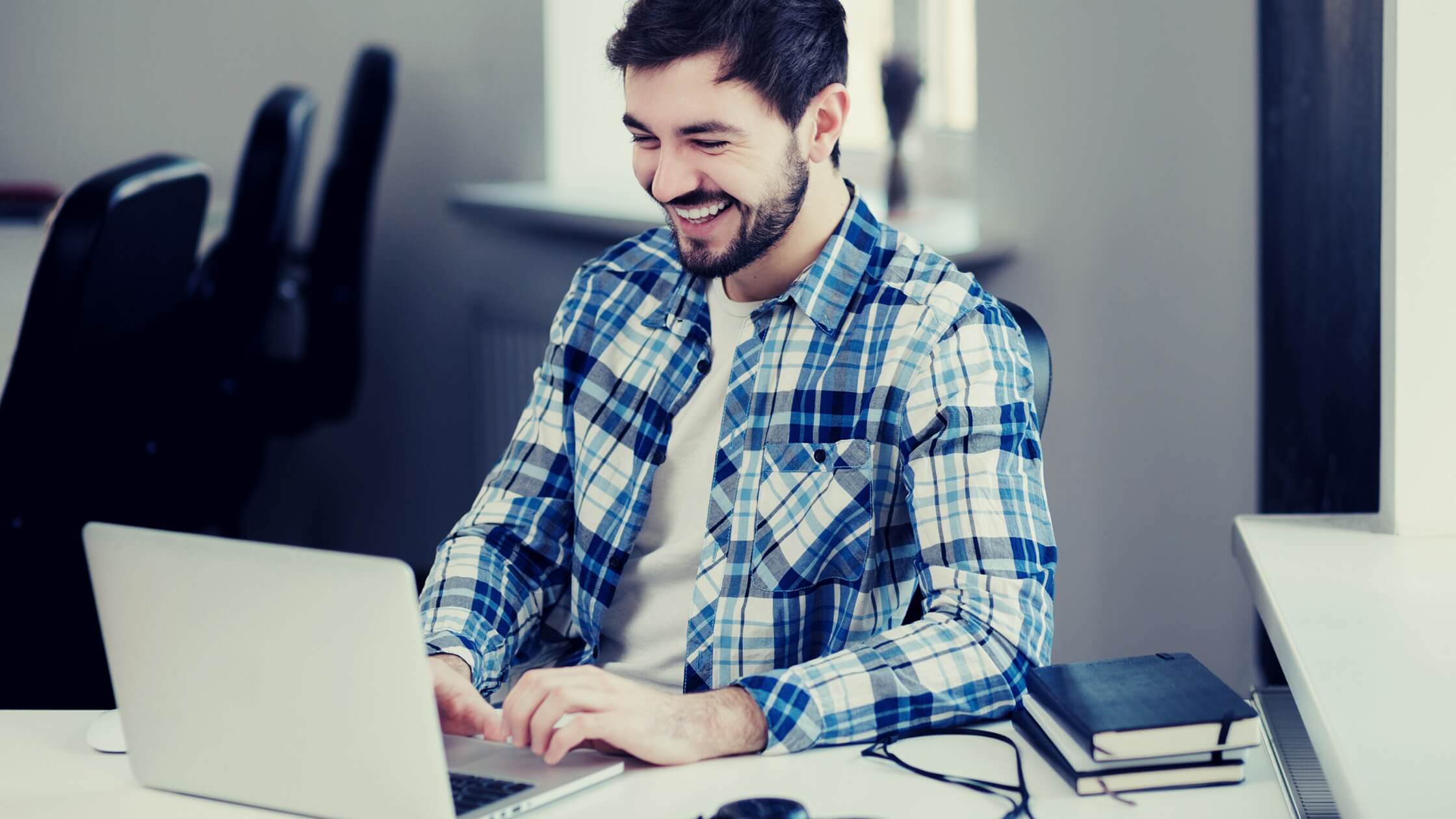 Hombre trabajando en su laptop sonriente