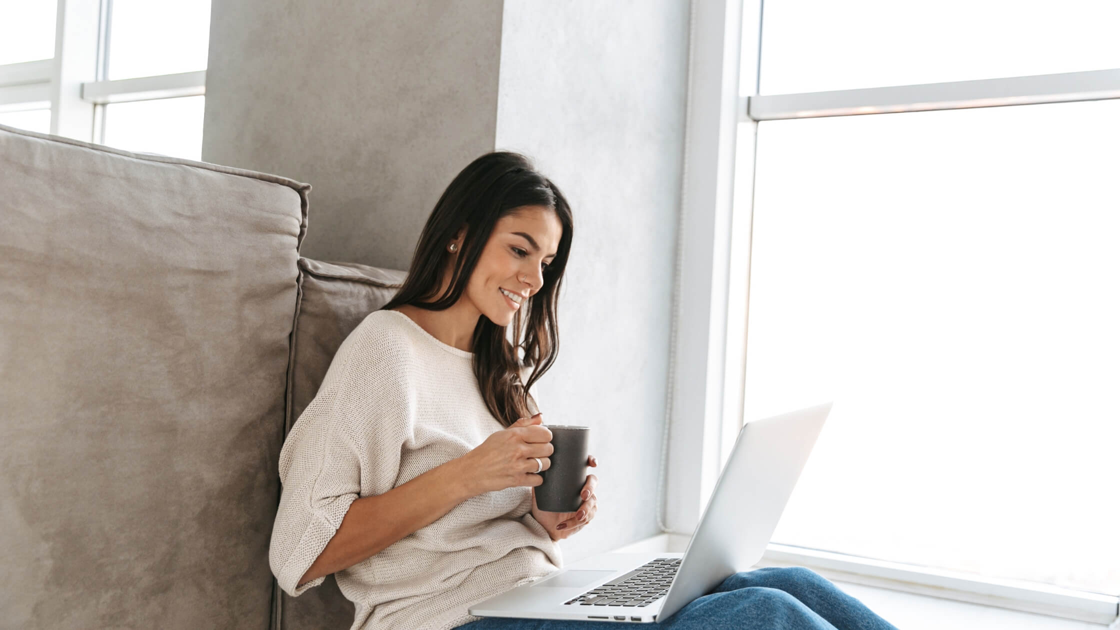 Mujer blogger trabajando desde su casa en su blog con su laptop