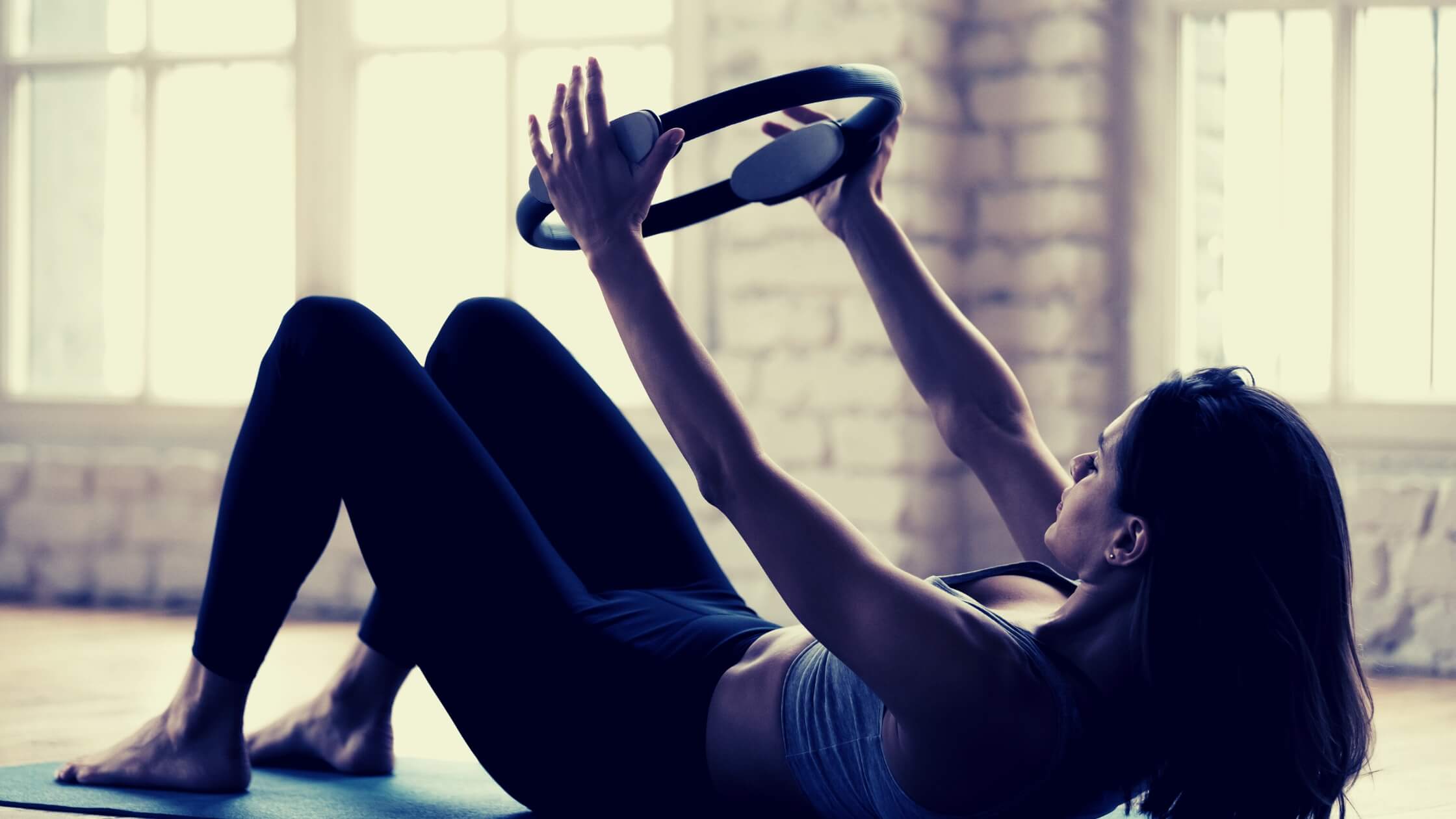 Mujer haciendo ejercicios con un aro de pilates